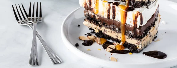 Vista de cerca de una rebanada de pastel de helado con sabor a chocolate y moca con salsa de caramelo y chocolate. — Foto de Stock