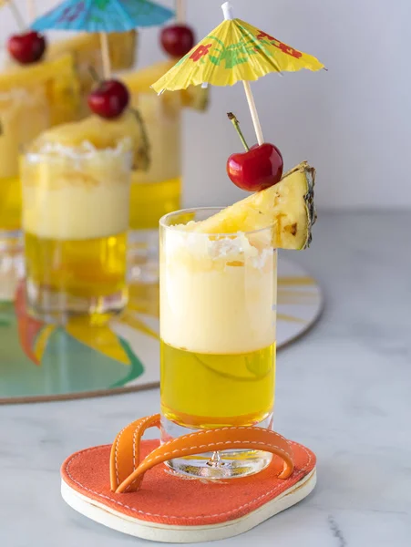 Zbliżenie galaretki ananasowej ozdobione klinem ananasowym, wisienką i szpikulcem do parasola gotowym do jedzenia. — Zdjęcie stockowe