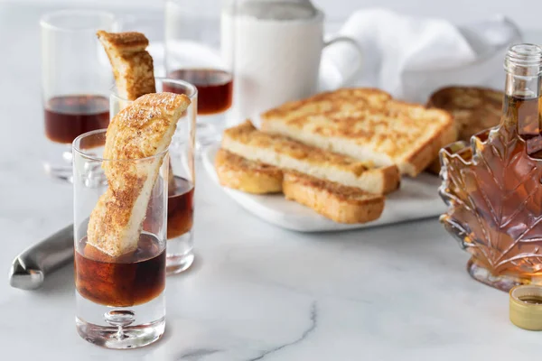 French toast shot glass appetizers surrounded by ingredients used to make them.