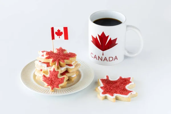 Placa de biscoitos de açúcar bandeira do Canadá com uma xícara de café contra um fundo branco brilhante. — Fotografia de Stock