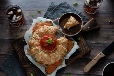 Bir dilim pizza dilimi alınmış, pizza sosu ve kola ile servis edilen bir pizza halkası..