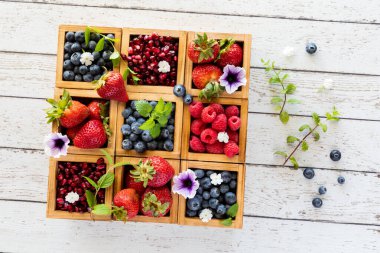 Tahta bir konteyner kutusundaki çeşitli meyveler hafif ahşap bir arka plana karşı..