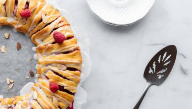 Bir ahududu halkasının yarısı yukarıdan alınmış bir tabak, spatula ve ortadaki fotokopi alanı ile..