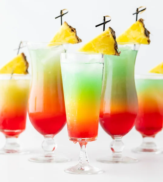 Close up of colourful cocktails with pineapple wedges, ready for drinking. — Stock Photo, Image
