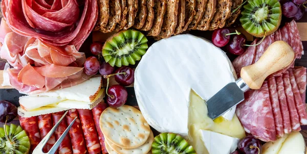 Top down view of various meats and cheeses, ready for snacking. — Stock Photo, Image