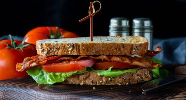 Pastırma ve domatesli sandviçi koyu bir arka planda görmek..