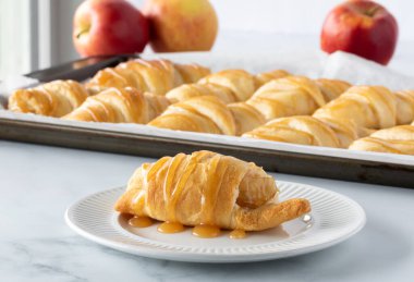 Karamel soslu hilal rulosu ve daha fazla rulo ile kaplı bir elmanın kapağını kapat..