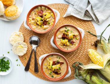 Bisküvilerle servis edilen üç kase tavuk ve mısır çorbası.. 