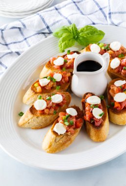 Ev yapımı bruschetta ile doldurulmuş, balzamik sirkeyle servis edilen, yemeye hazır bir tabağın kapağı..