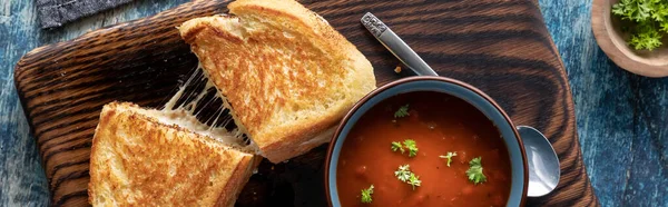 Vista de arriba abajo de un sándwich de queso a la parrilla servido con un tazón de sopa de tomate, listo para comer. — Foto de Stock