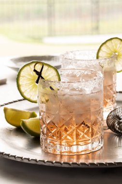 Bir margarita kokteylini tuzlu kenarlı ve limonla süslenmiş bir şekilde kapat..