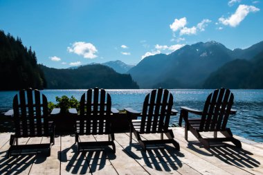 Manzaralı okyanus manzarasına bakan dört Adirondack sandalyesi.