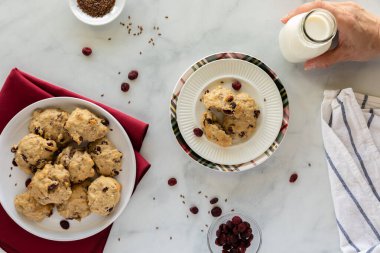 Yaban mersinli kahvaltılık kurabiyelerin yukarıdan görünüşü bir şişe sütle atıştırmaya hazır..
