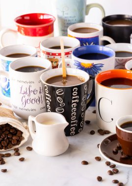 Kahve dolu fincanların dikey görüntüsü. Öndeki fincanın üzerindeki kahve kelimesine özenle odaklanmış.. 