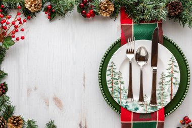 Çam ağacı ve kırmızı böğürtlen süslemeleri olan yeşil bir tatil masası..