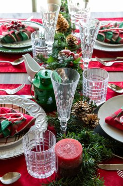 Zarif dekore edilmiş kırmızı ve yeşil bir Noel masası..