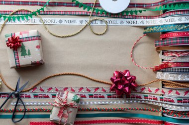 Hediyeleri paketlemek için kahverengi kağıda çeşitli renkli bayram kurdeleleri. Uzayı ortaya kopyala.