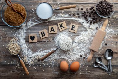 Kurabiye pişirmek için kullanılan çeşitli malzemelerin ve çatal bıçakların üzerinde. 