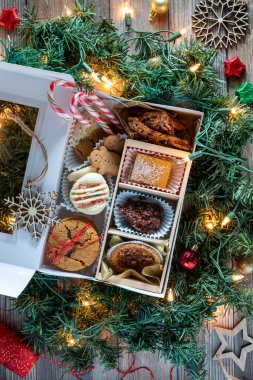 Noel süslemeleriyle çevrili nefis ev yapımı kurabiye kutusunun tepesinden aşağı..