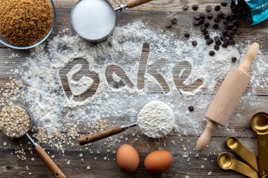 Çeşitli malzemelerle pişirme konsepti ve una yazılmış fırın kelimesi..