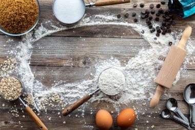 Pişirmede kullanılan malzemelerin bir arka planı, ortasındaki kopya alanı ile etrafa saçılmış..