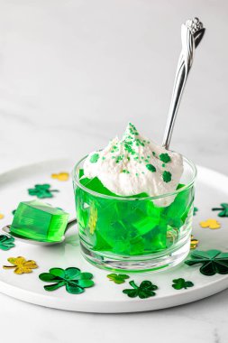 Aziz Patrick Günü için krem şanti ve yonca parçalarıyla kaplı yeşil bir tabak..