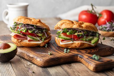 Tahta üzerinde taze ve sağlıklı malzemelerle yapılmış kruvasan sandviçleri..