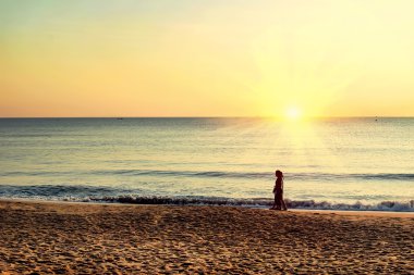 İnsanlar sahilde gündoğumu tadını çıkarın.