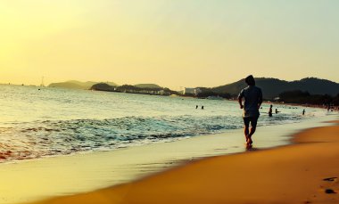 insanlar deniz kenarında gün batımında