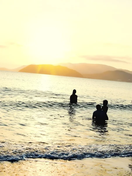 Les gens sur la plage profitent du lever du soleil — Photo