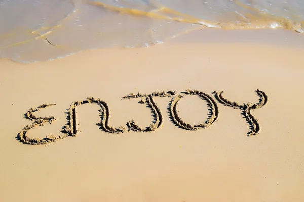 "Enjoy" written on sand — Stock Photo, Image