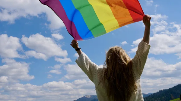 Person med hbt-flagga på himlen bakgrund — Stockfoto