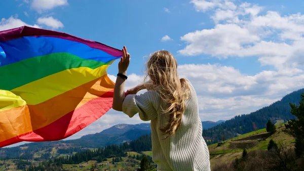Frau mit LGBT-Flagge auf Himmelshintergrund — Stockfoto