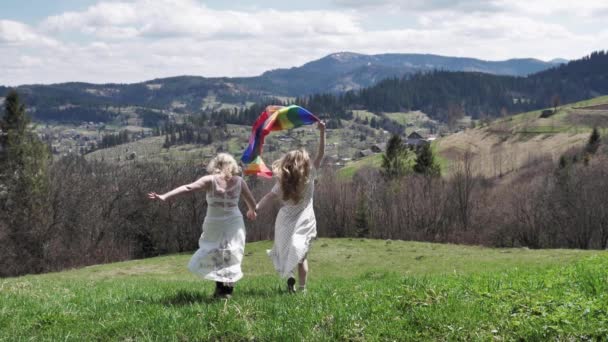 Lesbianas con bandera LGBT corriendo en vestidos de novia — Vídeo de stock