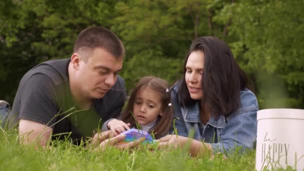 Μαμά, μπαμπάς και μωρό στη φύση παίζουν με ένα παιχνίδι Pop It — Αρχείο Βίντεο