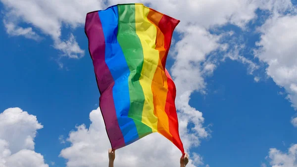 Bandera LGBT en las manos en el fondo del cielo — Foto de Stock
