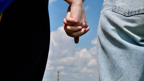 Lesbians hold hands close up on the sky background — Stock Photo, Image