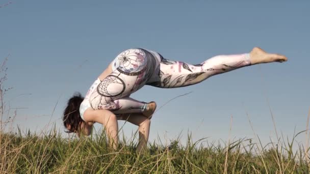 Chica haciendo yoga en verano al aire libre en ropa deportiva — Vídeos de Stock