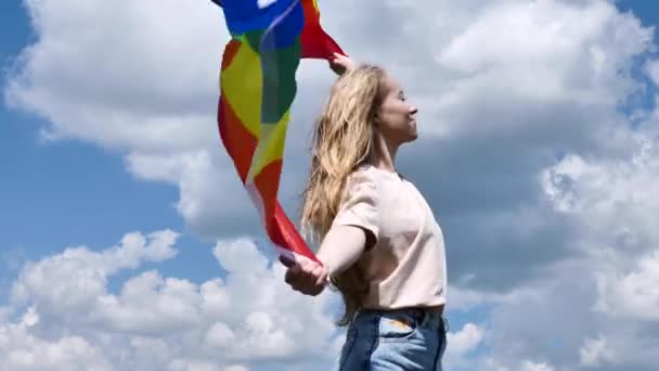 Bisexuell kvinna som håller hbt flagga på himlen bakgrund — Stockvideo