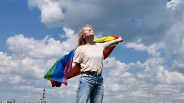 Bisexual γυναίκα κρατώντας σημαία ΛΟΑΤ στον ουρανό φόντο — Αρχείο Βίντεο