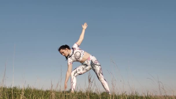 Flicka gör yoga på sommaren utomhus i sportkläder — Stockvideo