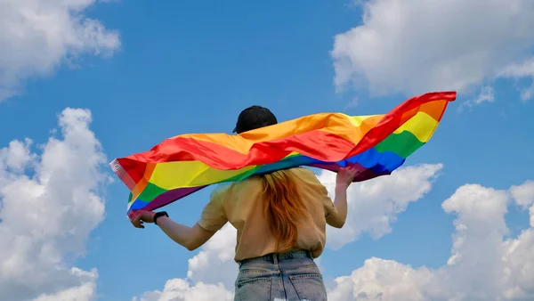 天空背景上挂LGBT旗的同性女性 — 图库照片