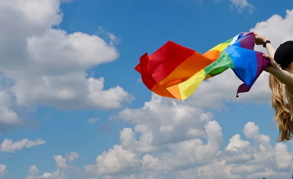 Homosexuelle Frau mit LGBT-Flagge auf Himmelshintergrund — Stockfoto