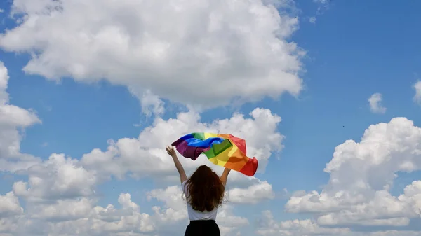 Pessoa segurando bandeira LGBT no fundo do céu — Fotografia de Stock