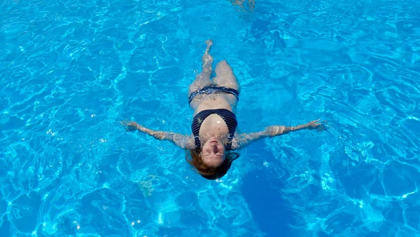 Woman swims in the pool in summer — Stockfoto