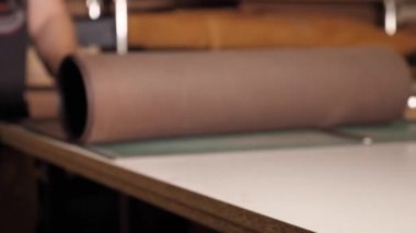 Adam küçük bir yapımda deriyle çalışıyor.