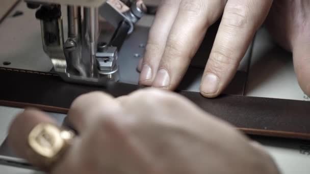 Uomo cuce una cintura di pelle su una macchina da cucire — Video Stock