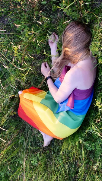 Lesbische Frau mit LGBT-Flagge auf einer grünen Wiese — Stockfoto