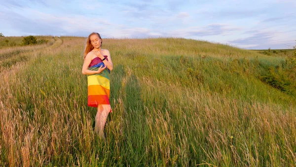 Femme lesbienne avec drapeau LGBT sur un champ vert — Photo