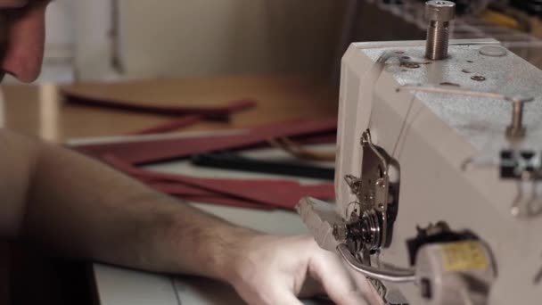 Man sews a leather belt on a sewing machine — Stock Video